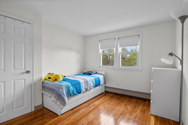 bedroom featuring a baseboard radiator and wood finished floors