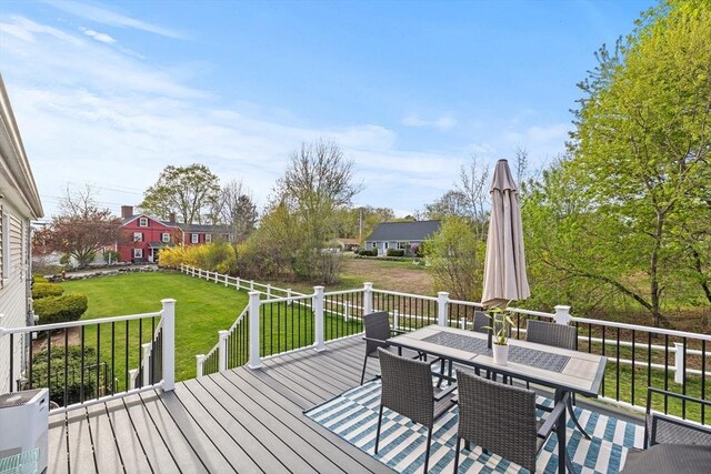 deck with a yard and outdoor dining area