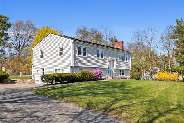 rear view of property featuring fence, a yard, a chimney, and entry steps