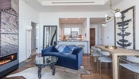 living room featuring dark hardwood / wood-style floors, a fireplace, and an inviting chandelier