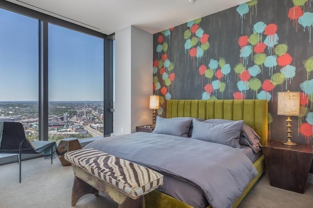 bedroom featuring light colored carpet and a wall of windows