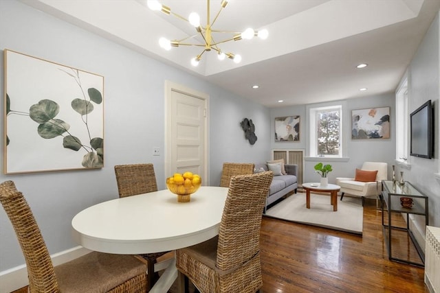 dining space with dark hardwood / wood-style flooring and a chandelier