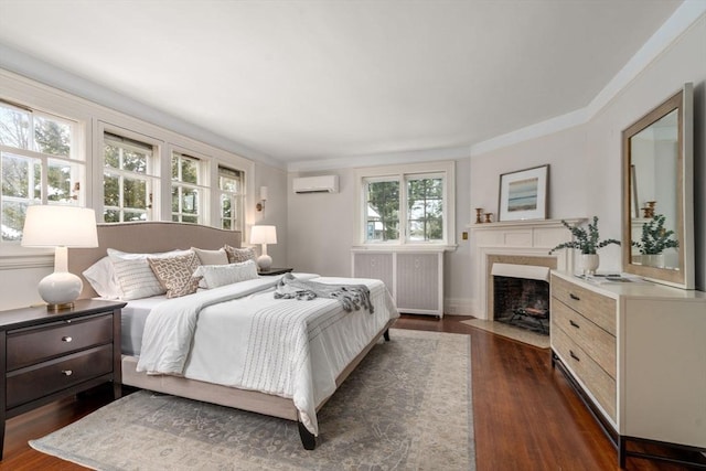 bedroom with a premium fireplace, a wall mounted AC, dark hardwood / wood-style floors, and radiator heating unit