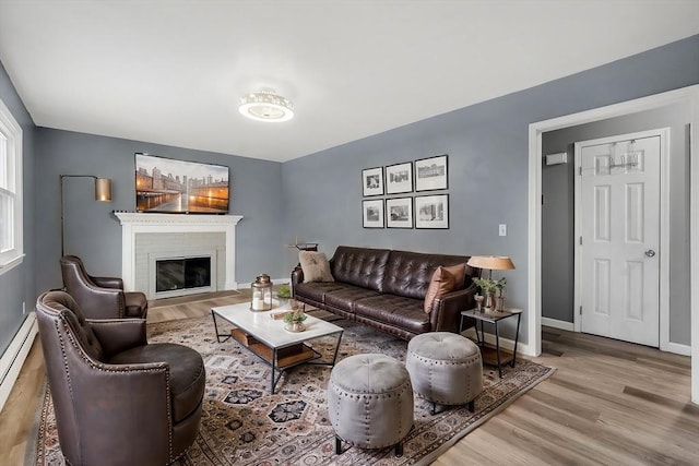 living room featuring baseboard heating and light hardwood / wood-style flooring