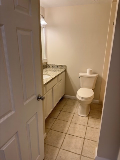 bathroom with tile patterned flooring, vanity, and toilet