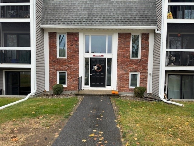 view of exterior entry with a yard