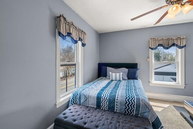 bedroom with a ceiling fan, baseboards, and carpet