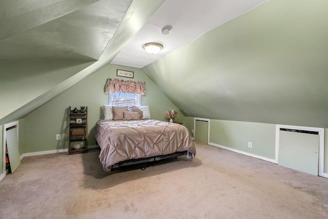 carpeted bedroom with baseboards and lofted ceiling