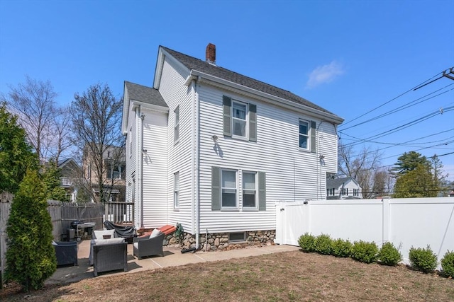 back of house with fence, a chimney, and a patio area