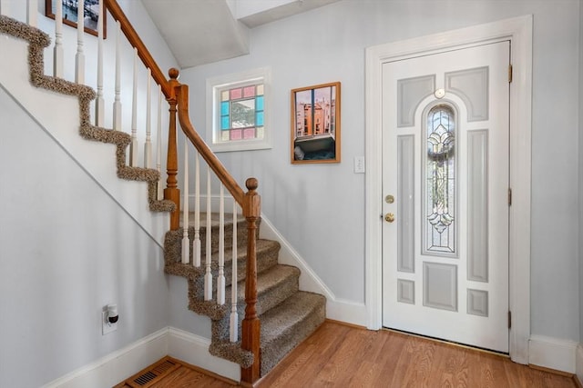 entryway featuring baseboards, a healthy amount of sunlight, and light wood-type flooring