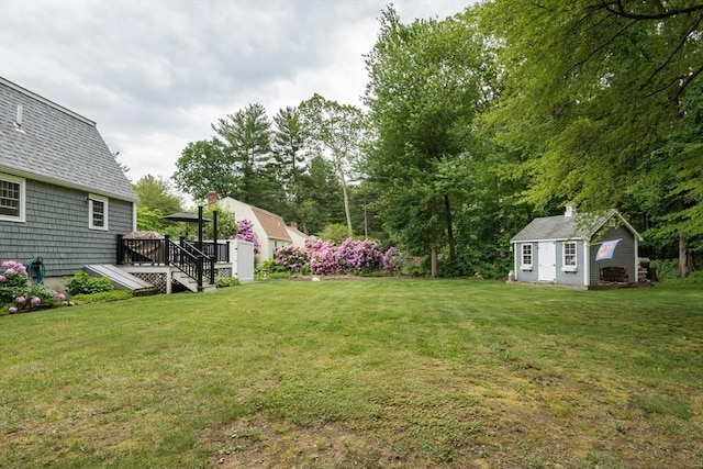 33 Cranberry Rd, Whitman, MA 02382 - view of grassy yard with an outdoor structure, a wooden deck, and view of wooded area