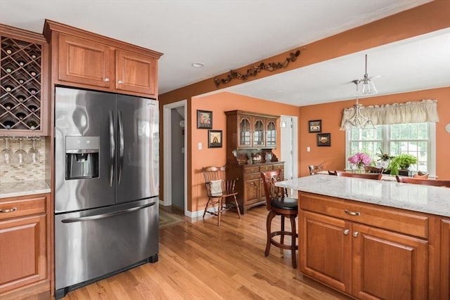 33 Cranberry Rd, Whitman, MA 02382 - kitchen with stainless steel fridge, brown cabinets, and tasteful backsplash