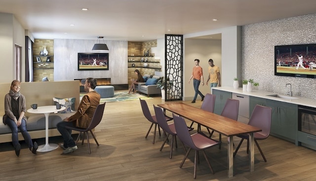 dining space featuring sink, hardwood / wood-style flooring, and a fireplace