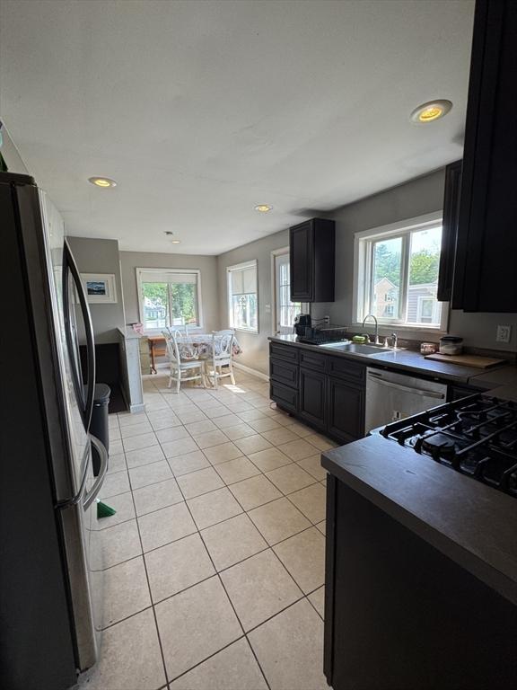 817 Middle St, Weymouth, MA 02188 - kitchen with stainless steel appliances, dark countertops, light tile patterned floors, healthy amount of natural light, and recessed lighting