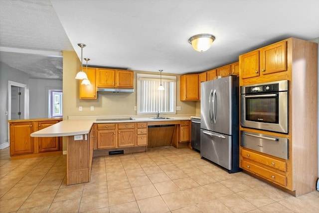 kitchen featuring appliances with stainless steel finishes, a warming drawer, a peninsula, a sink, and healthy amount of natural light