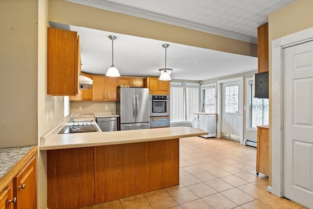 kitchen featuring appliances with stainless steel finishes, light countertops, a peninsula, decorative light fixtures, and light tile patterned floors