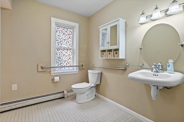 bathroom with a baseboard heating unit, toilet, baseboards, tile patterned floors, and a sink