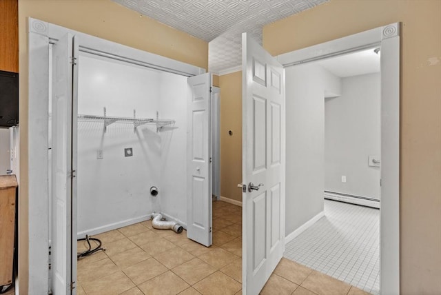 laundry area featuring a baseboard heating unit, an ornate ceiling, hookup for an electric dryer, light tile patterned floors, and baseboards