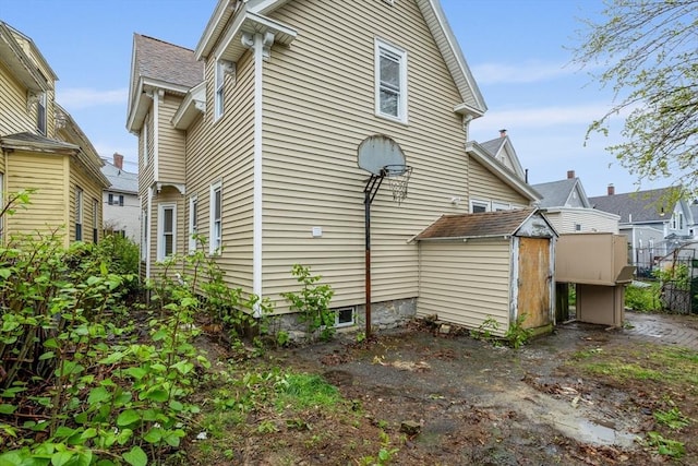 back of property featuring a shed and an outbuilding
