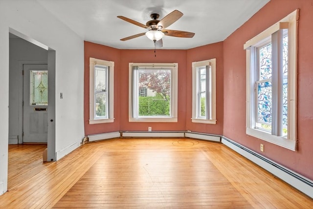unfurnished room with healthy amount of natural light, light wood-type flooring, and a ceiling fan