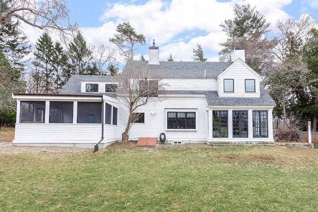 back of property featuring a shingled roof, a lawn, a chimney, and a sunroom