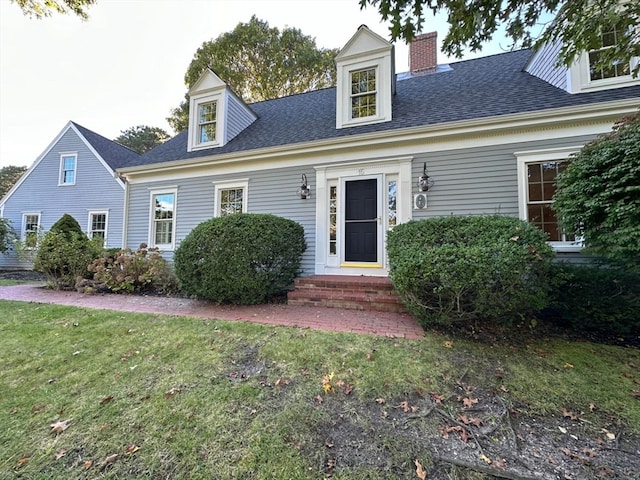 cape cod house featuring a front yard