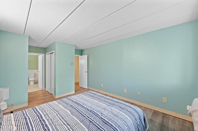 65 Commons Dr Unit 603, Shrewsbury, MA 01545 - bedroom with wood finished floors, a textured ceiling, and ensuite bath