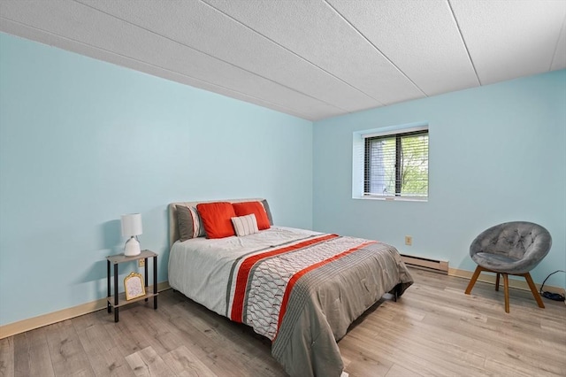 65 Commons Dr Unit 603, Shrewsbury, MA 01545 - bedroom featuring a baseboard radiator, light wood finished floors, and a textured ceiling