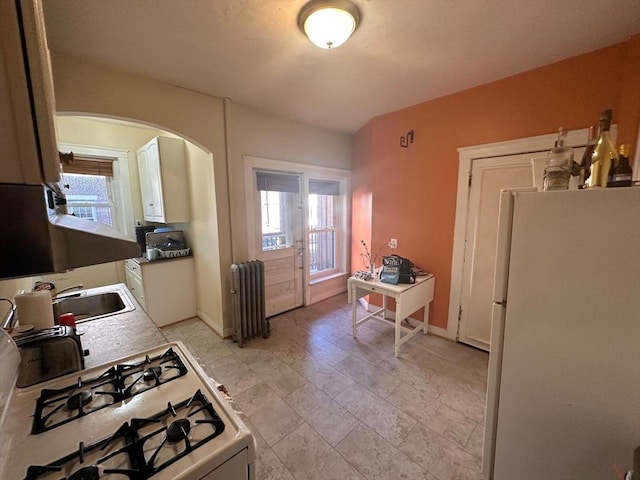 1269 Commonwealth Ave Unit 2, Boston, MA 02134 - kitchen with white appliances, radiator heating unit, arched walkways, a sink, and plenty of natural light
