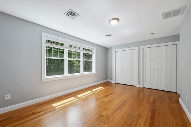 33 Oval Rd Unit 2, Quincy, MA 02170 - unfurnished bedroom with two closets, baseboards, and wood finished floors