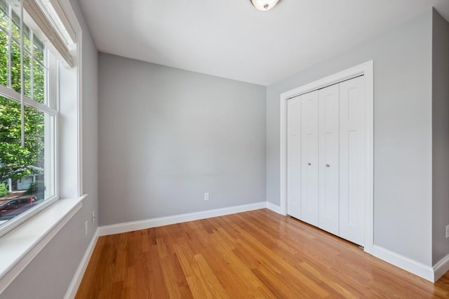 33 Oval Rd Unit 2, Quincy, MA 02170 - unfurnished bedroom featuring light wood-style flooring, baseboards, and a closet