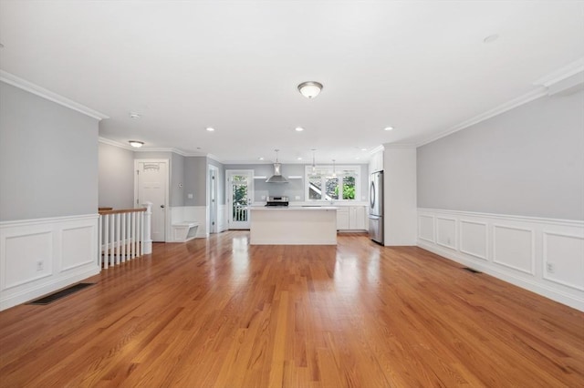 33 Oval Rd Unit 2, Quincy, MA 02170 - unfurnished living room with a wainscoted wall, light wood-style floors, ornamental molding, recessed lighting, and a decorative wall