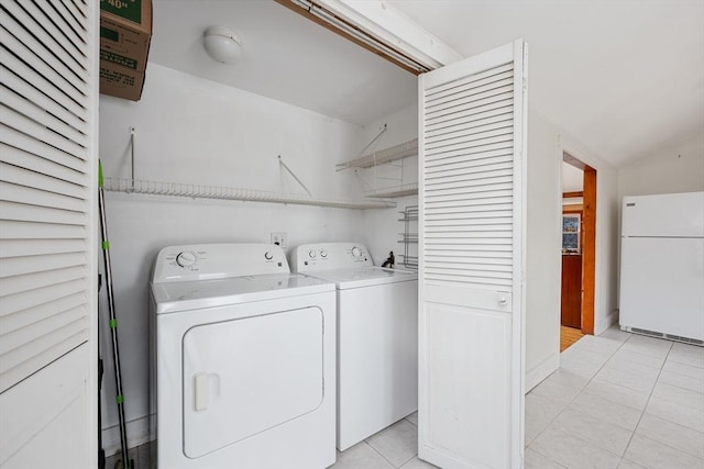 clothes washing area featuring laundry area, light tile patterned flooring, and independent washer and dryer