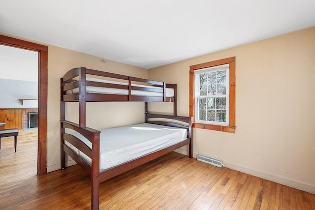 unfurnished bedroom featuring visible vents, wood-type flooring, and baseboards