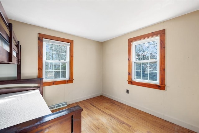 home office featuring baseboards, visible vents, and light wood finished floors