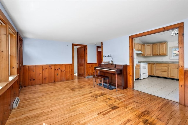 interior space featuring a wainscoted wall, wooden walls, visible vents, and light wood finished floors