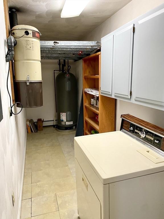 washroom featuring washer / clothes dryer, cabinets, and electric water heater