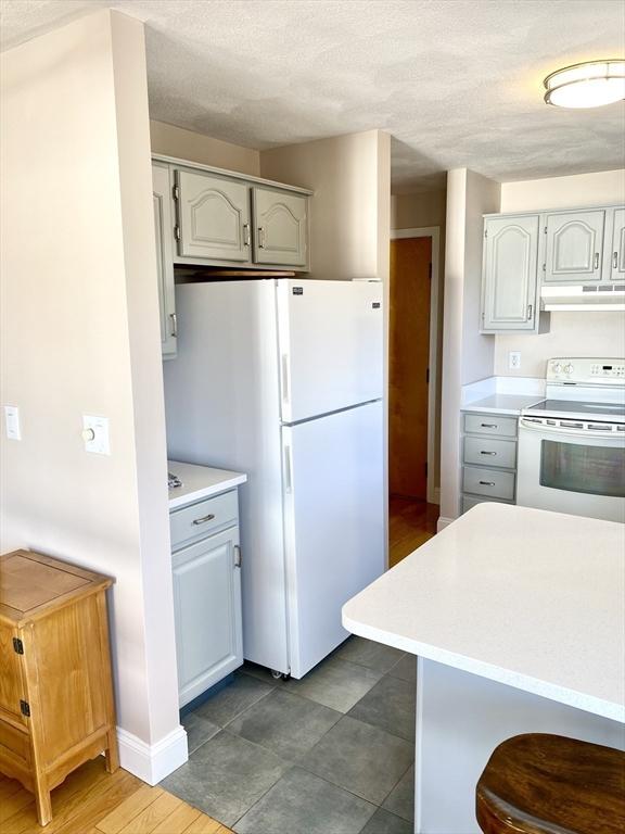 kitchen with white cabinetry and white appliances