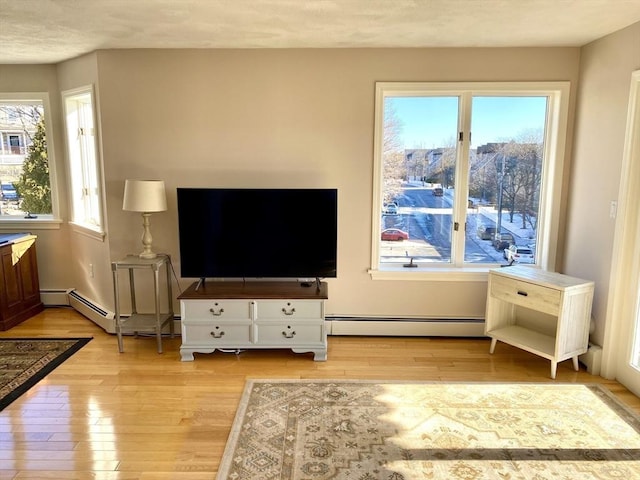 living room featuring baseboard heating and light hardwood / wood-style floors