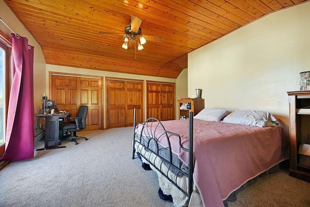 carpeted bedroom featuring vaulted ceiling, wood ceiling, and multiple closets
