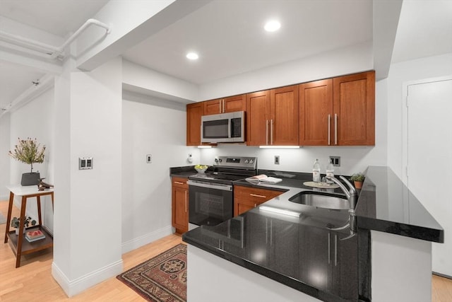 1600 Beacon St Unit 303, Brookline, MA 02446 - kitchen featuring stainless steel appliances, a sink, light wood-style floors, brown cabinets, and recessed lighting