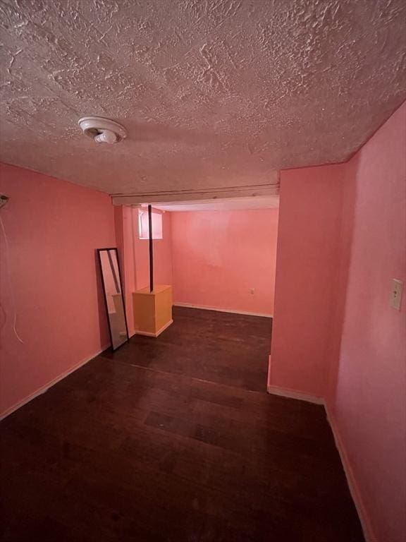 basement with dark wood-type flooring and a textured ceiling