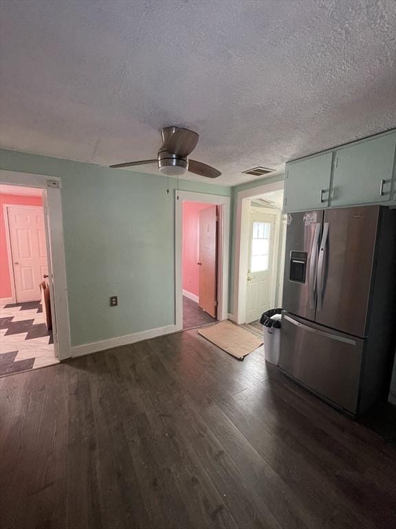 kitchen with dark hardwood / wood-style floors, ceiling fan, stainless steel fridge, and a textured ceiling