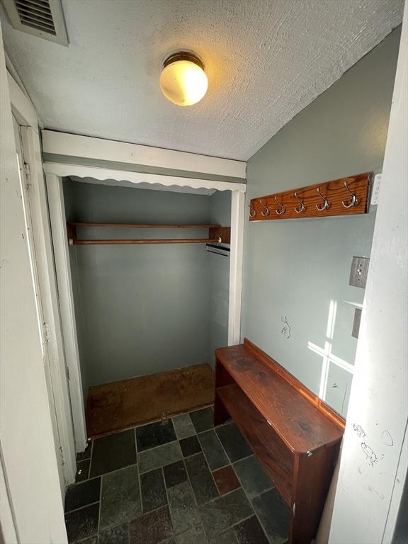 interior space with vaulted ceiling and a textured ceiling