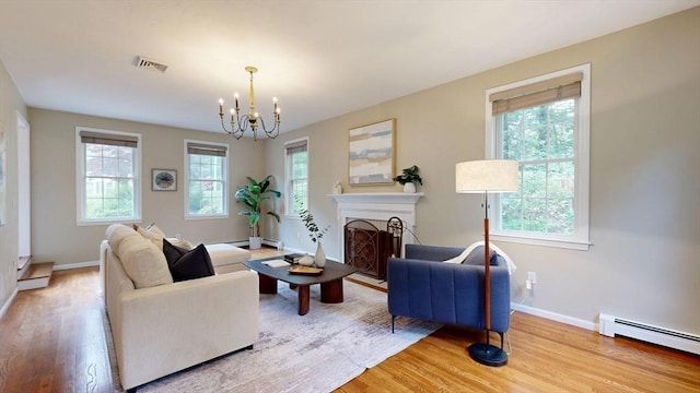 1 Ridgeway Rd, North Reading, MA 01864 - living area with a baseboard radiator, light wood-style floors, a chandelier, and a fireplace with flush hearth