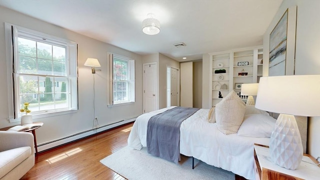 1 Ridgeway Rd, North Reading, MA 01864 - bedroom featuring a baseboard heating unit, wood finished floors, and multiple closets