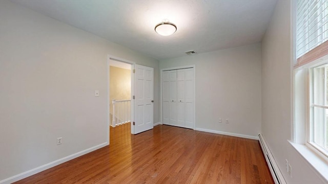 1 Ridgeway Rd, North Reading, MA 01864 - unfurnished bedroom with light wood-type flooring, a closet, and a baseboard heating unit