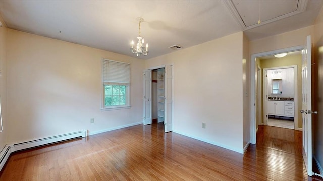 1 Ridgeway Rd, North Reading, MA 01864 - unfurnished bedroom featuring attic access, wood finished floors, a baseboard radiator, a closet, and a chandelier