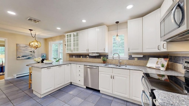 1 Ridgeway Rd, North Reading, MA 01864 - kitchen with appliances with stainless steel finishes, a peninsula, baseboard heating, decorative backsplash, and recessed lighting