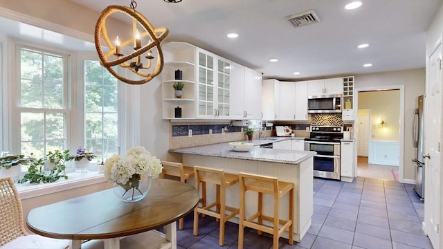 1 Ridgeway Rd, North Reading, MA 01864 - kitchen featuring appliances with stainless steel finishes, open shelves, a peninsula, tile patterned floors, and a chandelier